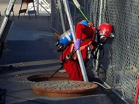 A City of Edmonton drainage employee enters the sewer system in West Jasper Place.