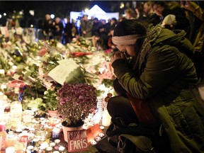 A woman prays at a makeshift memorial in front of the Bataclan theatre, one of the sites of the attacks in Paris, on Nov. 15, 2015, in Paris.