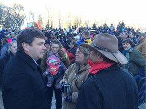 Alberta Agriculture Minister Oneil Carlier (left) talks with farmers during a protest rally against Bill 6 outside the legislature on Monday, Nov 30, 2015.