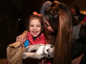 Three-year-old Syrian refugee Maysa Yousef is greeted at Calgary International Airport by family member Mishleen William on Nov. 20, 2015.