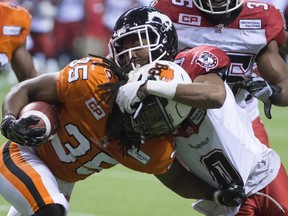 Calgary Stampeders' Ciante Evans, right, tackles B.C. Lions' Shaquille Murray-Lawrence during their final regular season game in Vancouver, on Nov. 7, 2015.