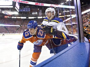 St. Louis Blues' Carl Gunnarsson (4) checks Edmonton Oilers' Matt Hendricks (23) on Thursday Oct. 15, 2015. Hendricks came off the Oilers injured reserve list on Tuesday, Nov. 3.