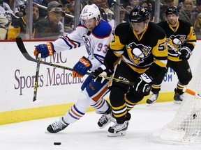 Pittsburgh Penguins' David Perron (57) and Edmonton Oilers' Ryan Nugent-Hopkins (93) battle for the puck during the second period of an NHL hockey game in Pittsburgh, Saturday, Nov. 28, 2015.