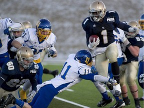 Notre Dame Pride's Ted Kubongo leaps past Bev Facey Falcons' Jett Slemko in a provincial high school semifinal for Tier 1 schools at Foote Field on Nov. 21, 2015 in Edmonton.