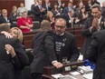 Alberta Tory interim leader Ric McIver gets a hug Wednesday as MLAs pay tribute to  Tory MLA Manmeet Bhullar at the Alberta Legislature. Bhullar was killed in a highway collision between Calgary and Edmonton on Monday.