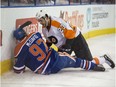 Connor McDavid of the Edmonton Oilers lies in a heap against the boards after a big hit from Brandon Manning of the Philadelphia Flyers at Rexall Place in Edmonton on Nov. 3, 2015..