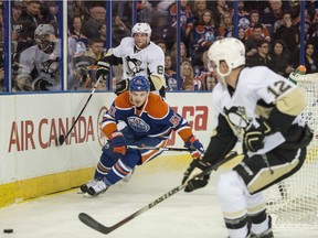 Anton Lander of the Edmonton Oilers, chases a puck passed to Ben Lovejoy of the Pittsburgh Penguins at Rexall Place in Edmonton.