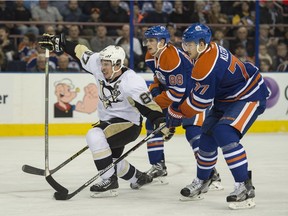 Brandon Davidson and Oscar Klefbom of the Edmonton Oilers keep close to Sidney Crosby of the Pittsburgh Penguins at Rexall Place in Edmonton on Friday, Nov. 6, 2015.