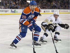 Iiro Pakarinen, of the Edmonton Oilers, moves the puck trailed by Brian Dumoulin of the Pittsburgh Penguins at Rexall Place in Edmonton.