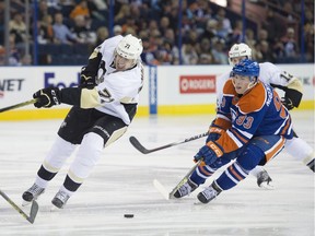 Ryan Nugent-Hopkins of the Edmonton Oilers, moves in on a puck missed by Evgeni Malkin of the Pittsburgh Penguins at Rexall Place in Edmonton.