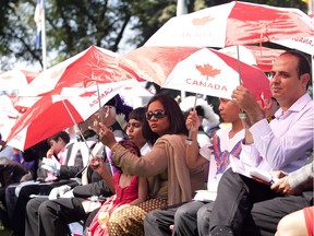 New Canadians listen during citizenship ceremonies at the Alberta Legislature during Canada Day activities on July 1, 2013 in Edmonton.