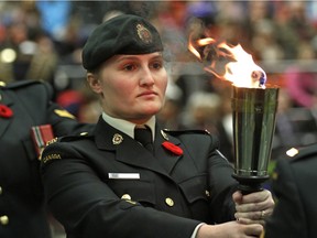 Private Maeli Vincent carries a torch during the City of Edmonton Remembrance Day Service held at the University of Alberta Butterdome on November 11, 2015.