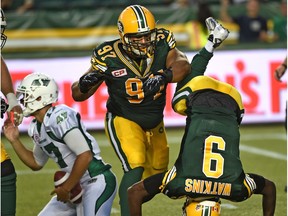 Edmonton Eskimos nosetackle Eddie Steele watches as Patrick Watkins celebrates a quarterback sack with a somersault in a Canadian Football League game at Commonwealth Stadium on July 31, 2015.