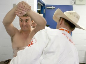 Bareback rider Kevin Langevin reacts as sports therapists tape ice on his ribs before Day 2 of the Canadian Finals Rodeo at Rexall Place in Edmonton on Nov. 12, 2015. Langevin broke six ribs, contused his lung and nearly destroyed one of his kidneys at a rodeo in Olds seven weeks ago.