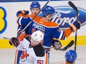 Edmonton Oilers' Oscar Klefbom (77) celebrates his goal on the New Jersey Devils with Oilers teammate Teddy Purcell (16) as the Devils' Sergey Kalinin (51) skates past during NHL action at Rexall Place in Edmonton on Nov. 20, 2015.