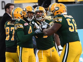 Edmonton Eskimos Adarius Bowman (4) celebrates with Tony Washington (58) after he scored a touchdown against the Calgary Stampeders during the CFL Western Final at Commonwealth Stadium in Edmonton on Sunday, Nov. 22, 2015.