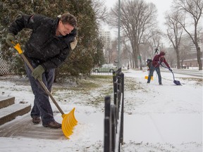 From left: Monty West, David Kozar and Shaun Materi shovel snow near 113th Street and 100th Avenue on November 23, 2015.