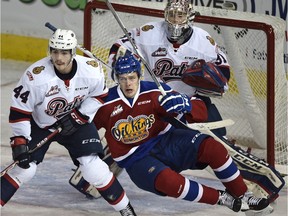 Edmonton Oil Kings Jesse Roach (17) gets taken down by Regina Pats Connor Hobbs (44) in front of goalie Tyler Brown (31) during WHL action at Rexall Place in Edmonton, November 26, 2015.