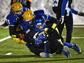 Ardrossan Bisons Jacob Krausher (18) gets tackeld by Willow Creek Cobras (yellow) in the Tier IV provincial football championships at Foote Field in Edmonton, November 28, 2015.