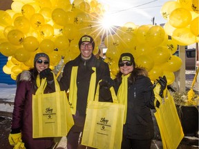 Left to right. Esha Malhotra, Wade Horb and Debora Olivier with Yellow Pages hand out reusable Shop The Neighbourhood shopping bags on Whyte Ave. in Edmonton on Nov. 28, 2015.