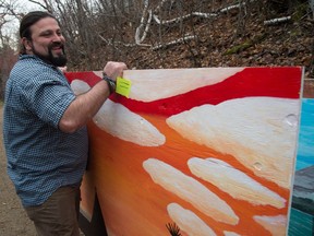 Sebastian Barrera, Parkdale Cromdale Community League president, with one of the panels being installed on a retaining wall in Kinnaird Ravine to reduce graffiti and crime.