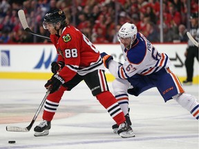 Patrick Kane (88) of the Chicago Blackhawks controls the puck in front of Benoit Pouliot of the Edmonton Oilers during NHL action at the United Center on Nov. 8, 2015, in Chicago.