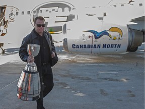 Head coach Chris Jones deplanes with the Grey Cup at the Edmonton International Airport. on Monday, Nov. 30, 2015.