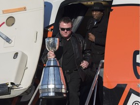 Head coach Chris Jones, front, and general manager Ed Hervey arrive in Edmonton with the Grey Cup on Monday.