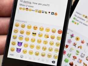 This Aug. 6, 2015 photo shows emoji characters, also known as emoticons, on the screens of two mobile phones.