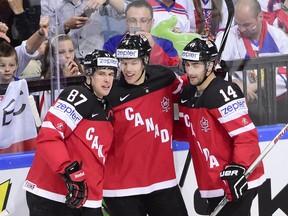 Forward Taylor Hall (centre) celebrates with Team Canada teammates, forward Sidney Crosby (left) and forward Jordan Eberle (right) after scoring a goal during the semi-final match against the Czech Republic at the 2015 IIHF Ice Hockey World Championships on May 16, 2015 in Prague.