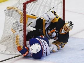 Edmonton Oilers' Ryan Nugent-Hopkins (93) slides into Pittsburgh Penguins goalie Jeff Zatkoff (37) during the first period of an NHL hockey game in Pittsburgh, Saturday, Nov. 28, 2015.