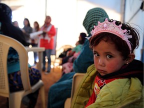 A child sits under a tent with Syrian refugee women attending a class on family planning organized by Doctors Without Borders at a makeshift camp by Taybeh village, in Lebanon's eastern Bekaa Valley.