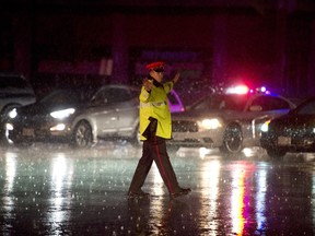 A police officer directs traffic in a powerless Mississauga due to heavy rains on July 8, 2013. The Ontario city is using green infrastructure to retain and treat rainwater for other uses.