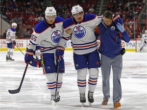 Edmonton Oilers' Nail Yakupov (10) is helped off the ice by teammate Mark Letestu, left, and trainer T.D. Forss following an injury during the second period of an NHL hockey game against the Carolina Hurricanes, Wednesday, Nov. 25, 2015, in Raleigh, N.C.