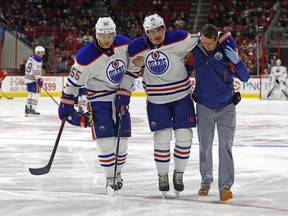 Edmonton Oilers' Nail Yakupov (10) is helped off the ice by teammate Mark Letestu (55) and trainer T.D. Forss following an injury during the second period of an NHL hockey game against the Carolina Hurricanes, Nov. 25, 2015, in Raleigh, N.C.