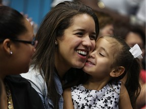 Nathalie Ogando sits with her five-year-old cousin, Lean Martinez, after the latter was adopted during a court ceremony in Miami on National Adoption Day, Nov. 20, 2015.