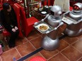 Two robots carry dishes and offer service for customers at a robot themed restaurant on Dec. 11, 2014, in Chengdu, China.