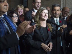 Surrounded by members of caucus Rona Ambrose speaks after being named as the interim-leader of the Conservative party following a caucus meeting Thursday November 5, 2015 in Ottawa.