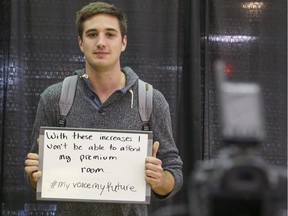 University of Calgary student Austin Backer uses a white board to express his opposition to the market modifiers (tuition increases) proposed by the former Tory government of Alberta. This photo was taken Nov. 6, 2014.