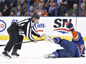 Edmonton Oilers' Taylor Hall gets a stick pulled from his skate by a linesman during a game against the Chicago Blackhawks in Edmonton on Wednesday Nov. 18, 2015.