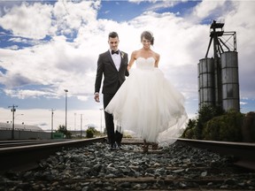 Alberta Ballet dancers Kelley and Reilley McKinlay walking along a rail track on their wedding day.