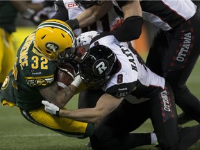 Edmonton Eskimos Kendial Lawrence (32) is tackled by Ottawa Redblacks Jake Harty during the 103rd Grey Cup on Nov. 29, 2015 in Winnipeg.