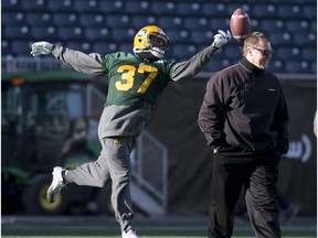 Edmonton Eskimos linebacker Otha Foster fails to catch the ball as head coach Chris Jones walks past during a practice on Nov. 27, 2015, at Winnipeg's Investors Group Field.