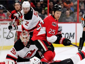 Chris Neil (C) battles with David Schlemko (R) as he attempts to clear the puck with goalie Cory Schneider looking on in the 1st period as the Ottawa Senators take on the New Jersey Devils in NHL action.  Assignment - 122480 (Wayne Cuddington/ Ottawa Citizen)