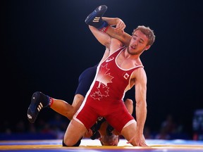 University of Alberta Golden Bears wrestler Mike Asselstine, pictured during  a competition with Viorel Etko of Scotland in the Men's 61-kilogram wrestling during the 2014 Commonwealth Games in Glasgow, is one of several local wrestlers competing in the Canadian wrestling team trials Dec. 4-6, 2015, at Millenium Place.