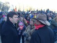 Alberta Agriculture Minister Oneil Carlier, left, talks with farmers during a protest rally against Bill 6 outside the legislature on Monday, Nov 30, 2015.