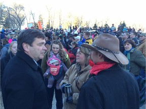 Alberta Agriculture Minister Oneil Carlier, left, talks with farmers during a protest rally against Bill 6 outside the legislature on Monday, Nov 30, 2015.