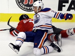 Edmonton Oilers defenceman Andrej Sekera is checked by Chicago Blackhawks left wing Andrew Desjardins during the third period of Thursday's game in Chicago. The Blackhawks won 4-0.