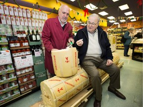 Joe Nicastro, left, delivers a 1,000-pound provolone to Anthony LoFrisco, 82, who travelled from Connecticut to see it in Ottawa on Dec. 1, 2015.