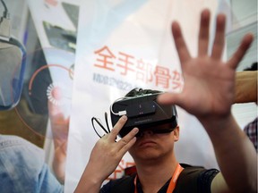 A visitor tries on virtual reality glasses from Oculus Rift Development Kit 2 (DK 2) during the first Consumer Electronics Show (CES) in Asia in Shanghai on May 26, 2015.